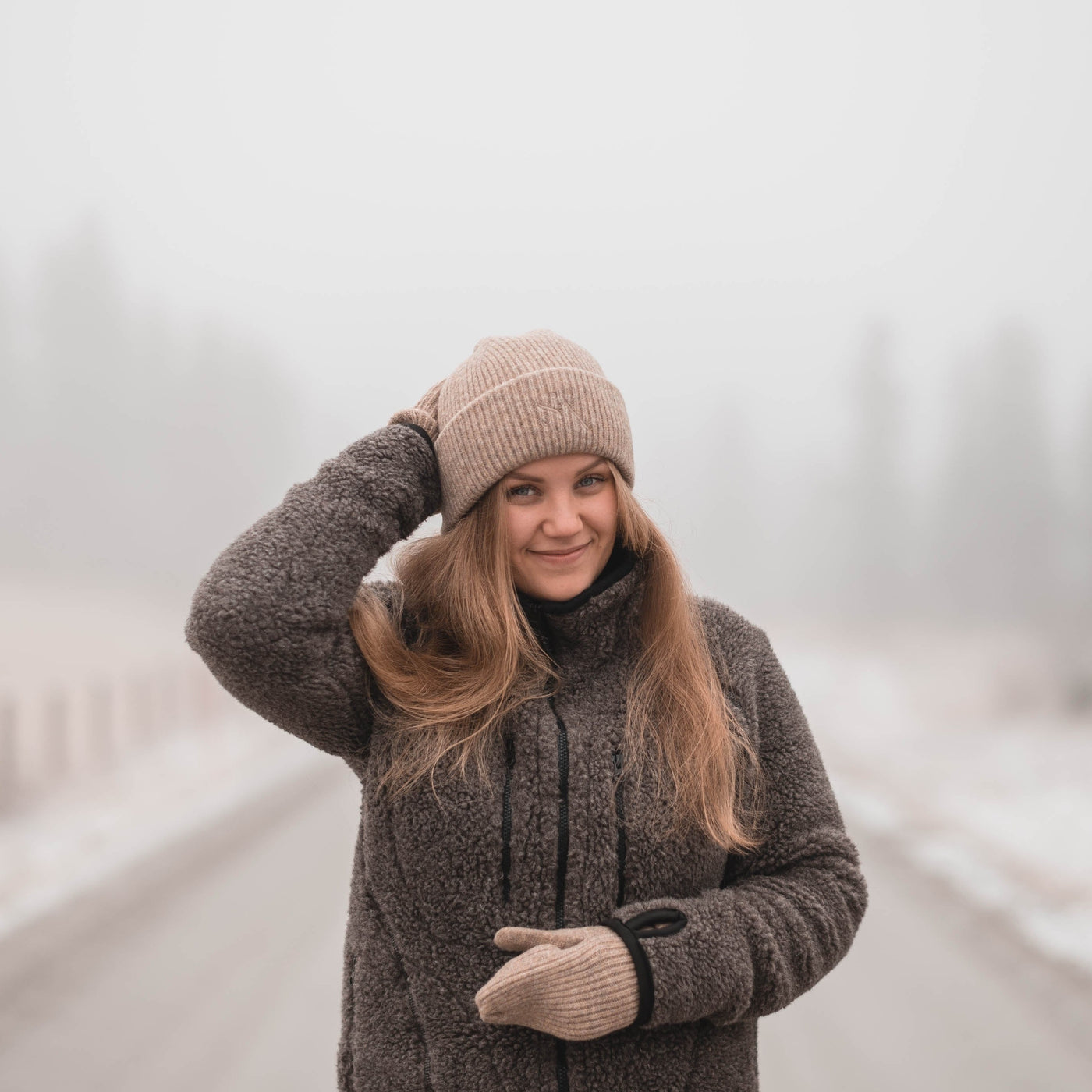 Sui Ava Beanie Sheepskin, lue i ullblanding i beige farge vist på jente utendørs